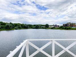 A beautifully designed white railing elegantly frames a breathtaking panoramic view of the serene water, creating a picturesque scene to fully admire natures beauty in all its glory photo