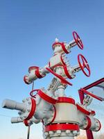 The image shows an Industrial Valve System against a vibrant blue sky, highlighting its intricate components and essential engineering connections for functionality photo