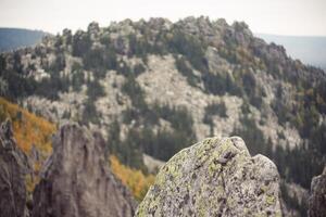 Mountain landscape with trees, rocks, and a prominent bedrock outcrop photo