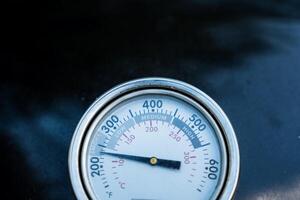 The closeup photograph captures a thermometer showing a high temperature of 400 degrees, highlighting its details clearly and emphasizing the measuring instruments features photo