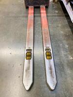 A pair of forklift forks is resting on a solid concrete floor, awaiting use in various lifting operations that they are designed for, showcasing their robust construction and utility photo