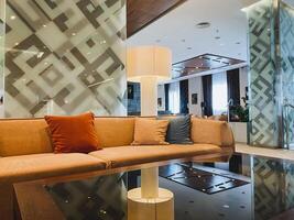 This exquisitely designed living room boasts a cozy couch, a stylish elegant table, and a warm lamp, all of which come together to create a truly comforting and inviting atmosphere photo