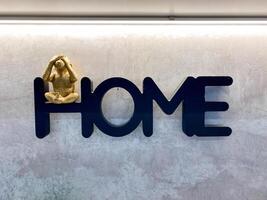 An intriguing monkey statue, whimsically placed on the word home, adds a delightful and charming touch to the overall decor and atmosphere of the entire space, creating warmth and joy photo