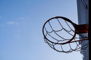 A basketball hoop is prominently displayed against the backdrop of a bright blue sky, creating a vibrant scene that captures the essence of outdoor sports and leisure activities photo