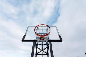 A basketball hoop stands proudly against a backdrop of a cloudy sky, creating a striking contrast that draws attention to this iconic symbol of the beloved game of basketball photo