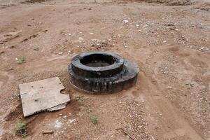 There is a desolate concrete structure on a rough dirt ground, abandoned and in a state of disrepair photo