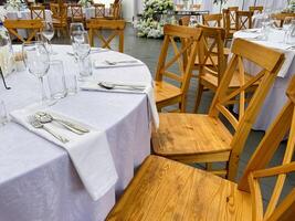 The tables and chairs are elegantly arranged for the wedding reception photo