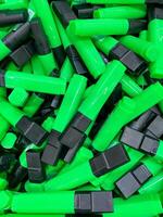 A neatly organized stack of green and black highlighters creates a vibrant contrast that adds an eyecatching pop of color to enhance the aesthetic of any workspace or desk area photo