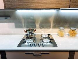 Imagine a beautifully designed kitchen that features a gas stove top oven, complemented by jars filled with various types of pasta, proudly displayed on the countertop for quick access photo