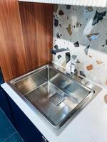 A highquality stainless steel sink in a contemporary kitchen is absolutely essential for both cooking and cleaning tasks, as it is a key plumbing fixture within that environment photo