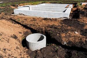 Installing concrete foundation and drainage system at construction site involves excavation, preparation, and installation of infrastructure for building development and safety measures photo