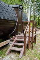 In the serene woods, there is a unique wooden barrel, complete with a set of stairs that leads up to it, creating an inviting and rustic access point amidst the natural surroundings photo