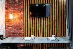The dining room features a spacious dining table elegantly placed in the center, accompanied by a modern flatscreen TV mounted on the wall for entertainment and relaxation photo