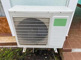 A white air conditioner is placed outside of a building, where it is positioned to help maintain a comfortable temperature indoors, showcasing its importance for climate control photo