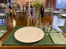 A table setting with a white plate on a vibrant green mat photo