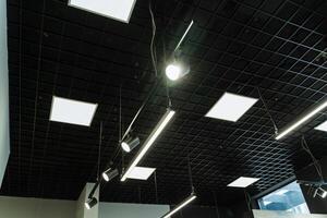 The ceiling is adorned with numerous hanging lights, creating a luminous atmosphere in the room. The fixtures add to the buildings ambiance, providing security and brightness photo