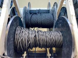 A collection of spools of rope is currently sitting neatly on a rack, waiting to be used for various purposes and applications in different fields such as engineering and manufacturing photo