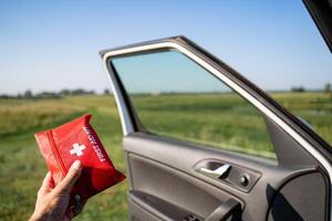 Emergency Preparedness A First Aid Kit Ready and Within Reach by the Car Door Situated in a Beautiful Open Landscape for Quick Access During Emergencies photo