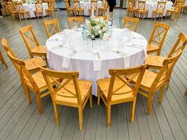 An elegant round dining table set designed specifically for events, featuring a charming floral centerpiece that enhances the overall ambiance photo