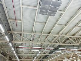 The spacious industrial warehouse features a contemporary ceiling designed with an advanced lighting system and modern air conditioning for optimal comfort and utility photo