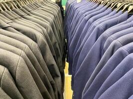 This diverse rack features a variety of dark sweaters, ideal for creating retail displays that effectively attract shoppers and enhance their wardrobe selections photo
