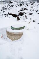 In the center of a vast, snowcovered field, there is an incongruous sight a solitary toilet, standing amidst the winter wonderland of frozen ice and frosty precipitation photo