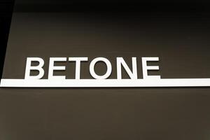 The white word betone stands out boldly against the brown background, becoming a prominent focal point in the design composition, captivating attention with its visual impact photo