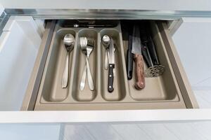 A tidy kitchen drawer features stylish cutlery and knives, all with a contemporary design for a clean, modern, and efficient look photo