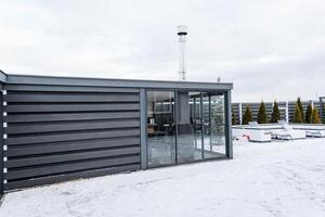 In a winter landscape, there is a building featuring a sliding glass door that is currently surrounded by a blanket of snow, creating a beautiful and serene scene in the cold weather photo