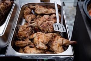 A beautifully arranged tray overflowing with succulent grilled chicken pieces and a spatula beside it, ready to serve a delightful meal. Enjoy the amazing taste that satisfies your hunger photo
