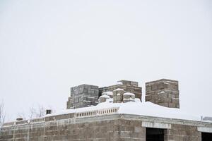 A building is currently under construction, and on its roof, there is a lovely soft layer of snow, adding a picturesque touch to the scene, especially in this winter weather photo