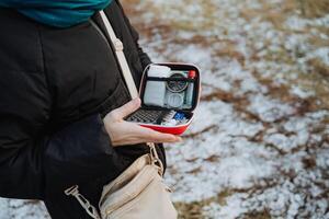 A highly capable woman maintains a wellstocked first aid kit, demonstrating her preparedness to tackle unexpected emergencies that may occur during her outdoor adventures or travels photo