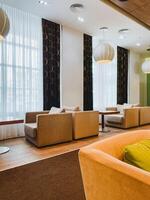 The living room is furnished with an abundance of chairs and tables, creating a vibrant and comfortable atmosphere for relaxation and socializing, perfect for any home setting photo
