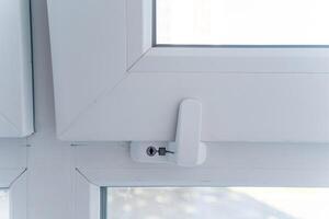 This image showcases a detailed closeup view of a pristine white window that features a secure lock on it, emphasizing its design and practicality in terms of safety and functionality photo