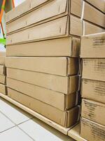A significant stack of cardboard boxes has been meticulously stacked on top of each other, creating a neat and organized arrangement that showcases their rectangular shape and durability photo