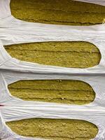 The image shows a neatly stacked pile of highquality rock wool insulation, securely packed in durable plastic bags for safe storage, easy handling, and convenient transport photo
