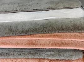 Experience the ultimate relaxation with our soft and cozy plush towels, beautifully stacked in an array of warm and inviting colors photo