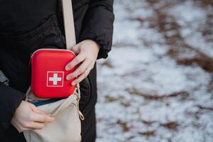 A person is confidently holding a first aid kit in their hand, displaying their preparedness for any medical emergencies that could occur in a wide range of situations or outdoor activities photo