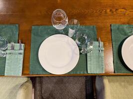 There is a table that is set with plates and glasses placed on it photo