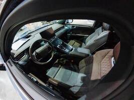 The inside of a car is visible with the door open, showcasing the steering wheel prominently, offering a clear view of the interior features and layout that make up the vehicles design photo