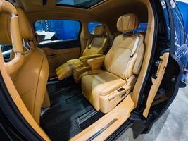 The interior space of a sleek black car is elegantly furnished with luxurious brown leather seats that exude comfort, style, and sophistication, making it a truly impressive vehicle photo
