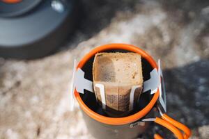 Discover the simplicity and convenience of brewing coffee outdoors using a portable filter in a camp mug on an exciting journey, blending adventure with functionality photo