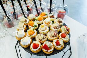 A stunning display of cupcakes with various toppings on a table at an event or party, enticing guests to indulge in the delicious treats and satisfy their sweet tooth cravings photo