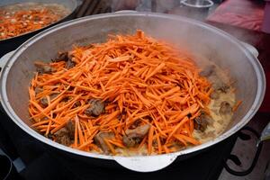 Carrots are being added to a steaming pot filled with various ingredients, significantly enhancing both the overall flavor profile and the nutritional value of the finished dish photo