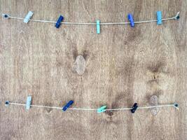 Clothes pins are neatly hanging on a clothes line stretched across a lovely wooden surface, showcasing a vibrant mix of colors and textures that enhance their environment photo