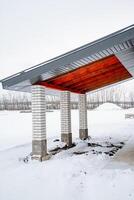 A beautifully covered outdoor area featuring elegant columns and a sturdy roof, adorned with a soft blanket of snow that enhances its visual appeal in the cold winter season photo