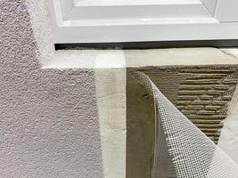 A detailed close up view of a window being meticulously installed into a wall, highlighting the intricate details of the materials used and the craftsmanship involved in the process photo