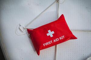 The first aid kit is red in color and prominently features a white cross symbol on its exterior, making it easily recognizable for emergency situations and healthrelated needs photo