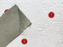 Repairing a Textured Wall This involves the careful application of drywall compound along with the use of red anchors, ensuring a smooth finish for a polished look photo