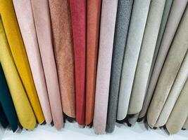 A collection of variously colored fabrics has been neatly stacked on top of each other, showcasing a rich diversity in textures and hues that are visually striking for any textile lover photo